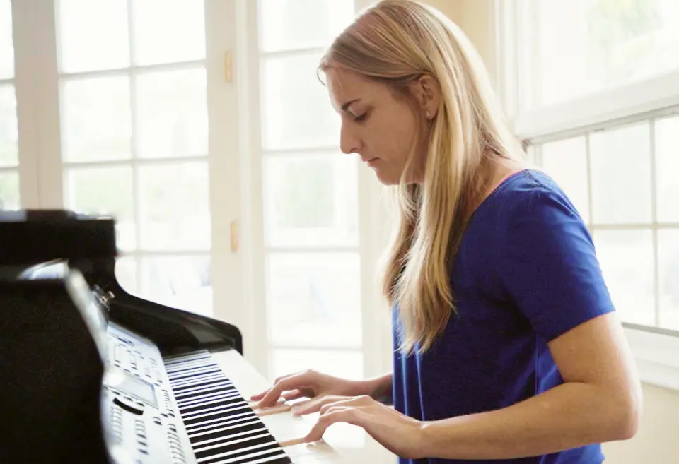 A Villa Oasis resident playing the piano in the common room
