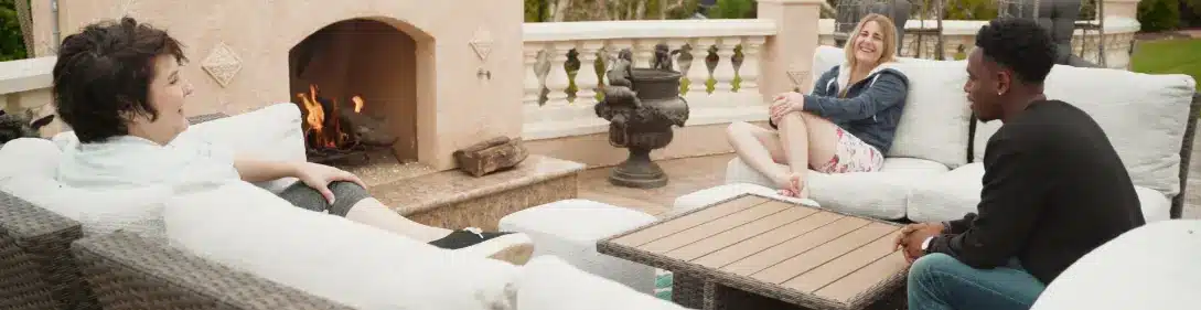 Villa Oasis residents sit in an outside seating area and laugh while having a conversation