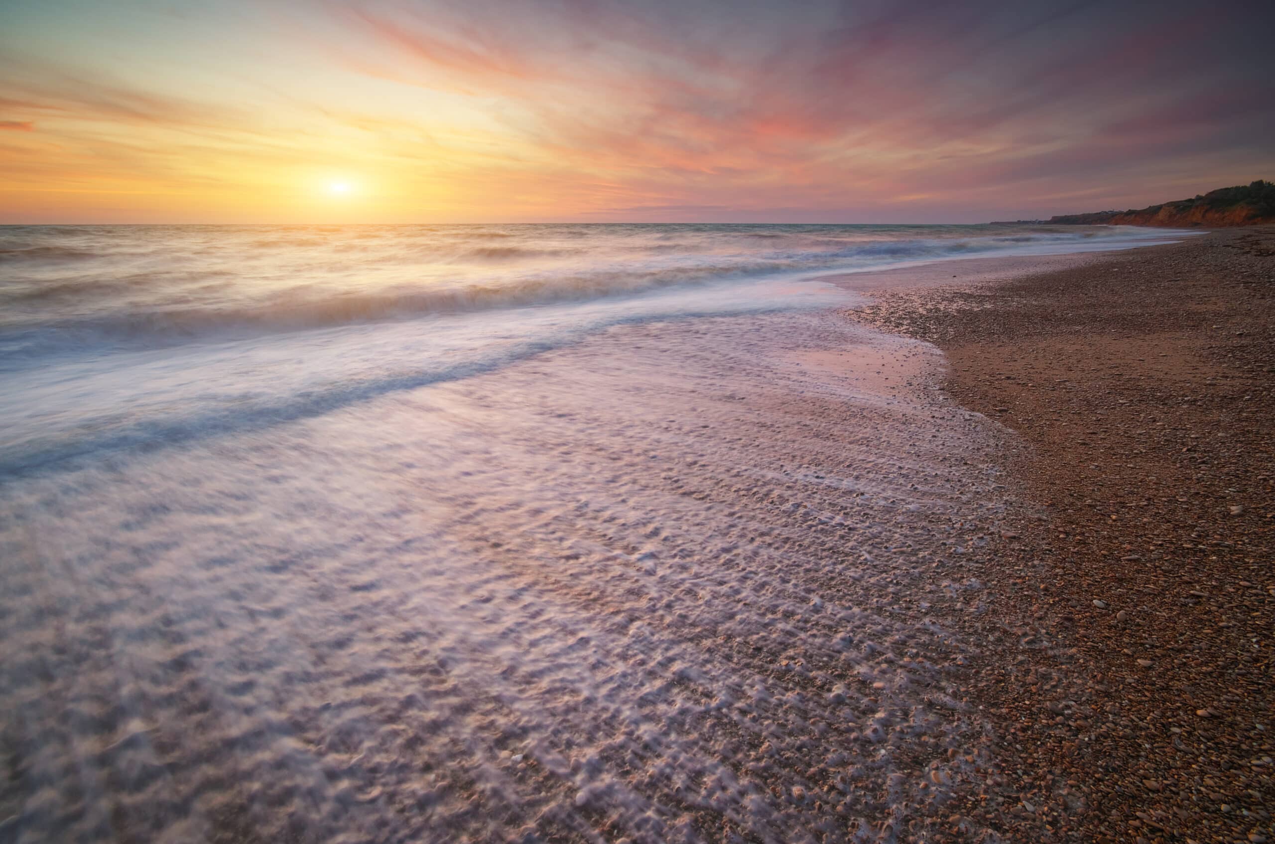 beach at sunset with water going back
